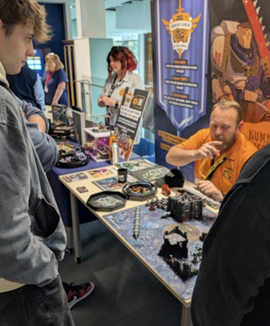 Marketing Assistant Carla Lorimer and Computing Lecturer Chris Connor at the Grimdark Gamers Club Table speaking to students